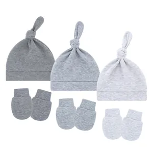 Detail view of baby knot hat and anti-scratch mitten set in three shades of grey