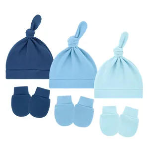 Detailed view of three-set infant knotted hats and no-scratch mittens in blue shades