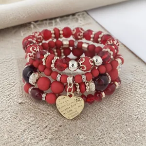 Close-up of Bohemian red beaded bracelet set with engraved heart pendant
