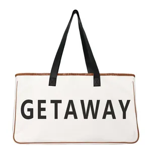 Close-up view of a large canvas tote beach bag with black handles and GETAWAY print.