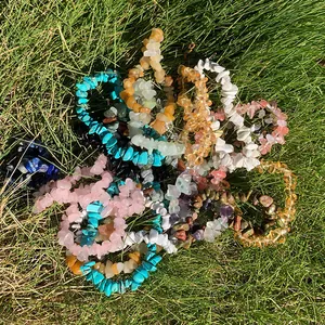 Primo piano di vari braccialetti elastici in pietra naturale su sfondo di erba verde.