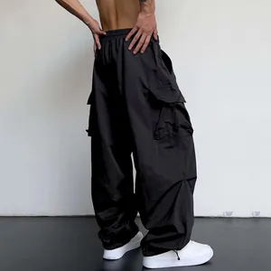 Detail view of black baggy parachute cargo pants with adjustable drawstring cuffs.