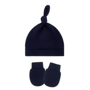 Detailed view of navy blue baby knot beanie hat and matching anti-scratch mittens set