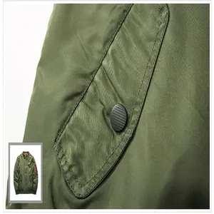 Primer plano del bolsillo lateral de la clásica chaqueta bomber MA1 verde con botón