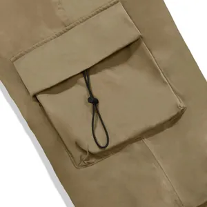 Close-up detail of cargo pocket with adjustable drawstring on nylon parachute pants