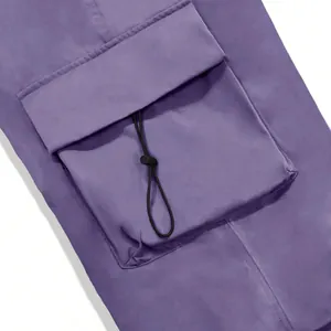 Close-up detail of purple quick-drying cargo pants featuring a flap pocket with toggle cord.