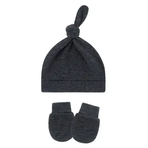Dark gray infant knot beanie hat and matching anti-scratch mittens set on white background