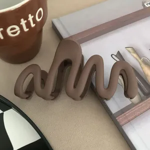 Close-up detail of a matte wavy hair claw clip in elegant coffee brown