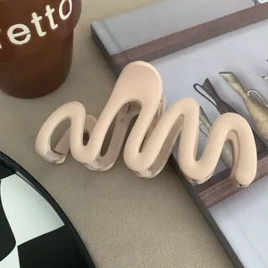 Close-up detail of a matte wavy hair claw clip in elegant nude beige for hair styling