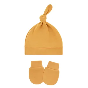 Soft mustard yellow cotton knit baby knot hat and matching anti-scratch mittens set