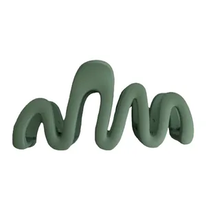 Matte green wave-shaped hair claw clip with minimalist design and non-slip grip