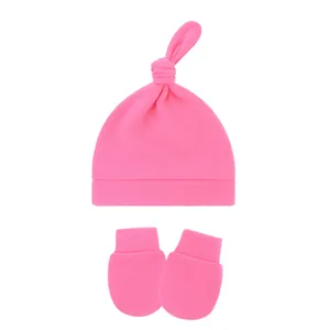 Detailed view of soft pink cotton baby knotted beanie hat and scratch mittens set for newborns