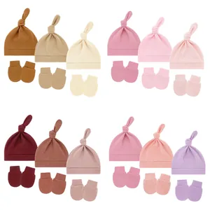 Set of soft cotton baby knot hats and no-scratch mittens in various solid colors