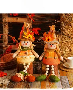 Handmade autumn harvest scarecrow gnomes with maple leaf decor sitting on wooden stumps