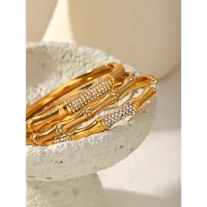 A detailed macro view of a gold rhinestone bamboo-shaped stainless steel bangles set.