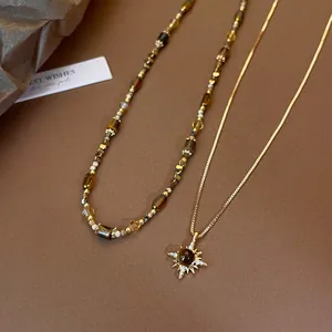 Vintage gold sunburst tiger eye stone necklace set on aesthetic brown background