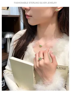 Elegant Asian model showcasing a heart-shaped peridot and sterling silver jewelry set