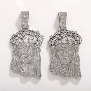 Macro detail of two silver hip-hop Jesus head pendants fully iced out with CZ stones