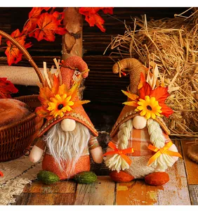Close-up of Thanksgiving gnomes with harvest maple leaves and straw hat details.