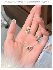 Heart-shaped yellow crystal jewelry set with necklace, earrings, and ring in hand