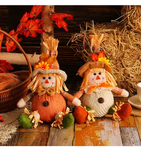Detail shot of two Thanksgiving scarecrow dolls with harvest maple leaf decorations