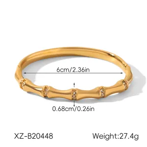 Detail view of a gold bamboo-shaped stainless steel bracelet with rhinestones