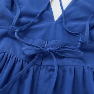 Close-up of a blue cotton linen dress showing back tie and invisible zipper details.