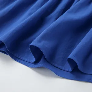 Detailed view of blue cotton linen dress hem showing fine fabric texture and stitching