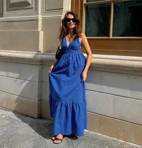 Woman wearing an elegant blue V-neck cotton linen maxi dress with tiered hem outdoors
