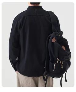 Detail back view of a men's black Japanese style cotton denim shirt with a black backpack