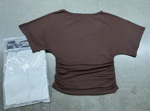 Detailed view of women's brown batwing sleeve t-shirt featuring elegant ruched waist design