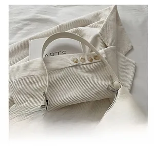 Detail showing texture of cream white faux leather underarm hobo bag with silver zip