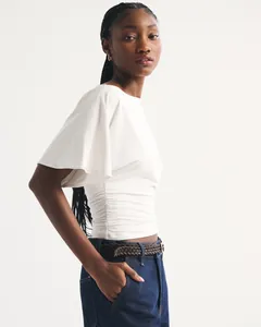 Detailed side view of white women's t-shirt featuring batwing sleeves and ruched waist detail
