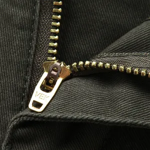 Vue détaillée de la fermeture éclair en métal doré sur un pantalon décontracté pour hommes