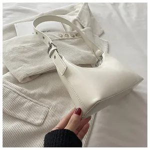 Close-up of a chic white armpit bag with glossy leather texture and adjustable strap.