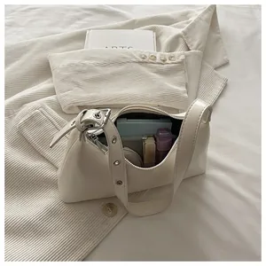 Detail view of cream underarm bag showing interior capacity and stylish silver hardware