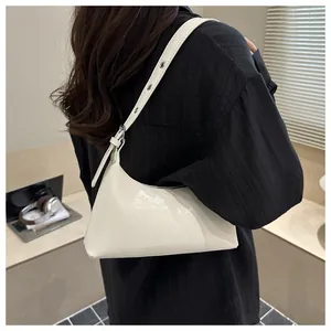 Rear view detail of a chic white patent leather underarm shoulder bag for women
