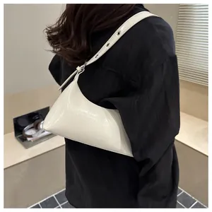 Stylish minimalist white patent leather underarm bag for women shown on a fashion model