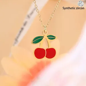 Dainty gold-plated necklace featuring a vibrant red and green enameled cherry pendant