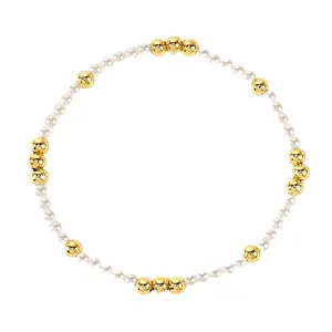 Minimalist imitation pearl stretch bracelet with gold-tone round beads on white background.