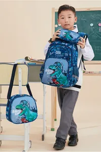 Blue three-piece school bag set for boys with cool dinosaur print in classroom setting