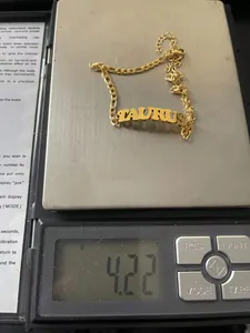 Detailed view of 18K gold color Taurus zodiac anklet weighing 4.22 grams on a scale