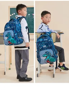 Young boy wearing a blue ergonomic school backpack with dinosaur print in a classroom