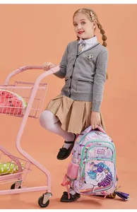 Child model holding a purple unicorn school backpack next to a pink shopping cart