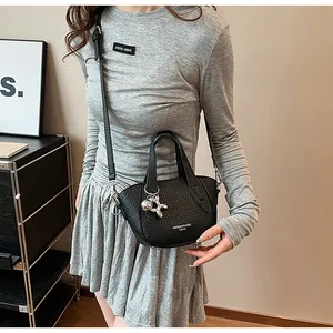 Chic black lychee pattern handbag with silver dog charm, crossbody style for women