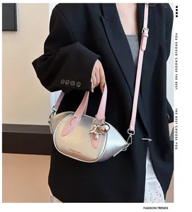 Detail view of silver metallic handbag with pink straps and silver balloon dog charm