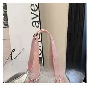 Close-up detail of the pink leather handles on a silver metallic bucket bag for women