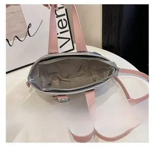 Interior view of silver and pink bucket bag showing patterned lining and zipper pocket.