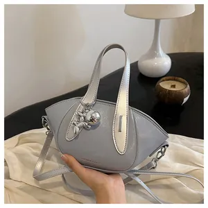 Close-up detail of a light blue fashion bucket bag featuring a silver balloon dog charm