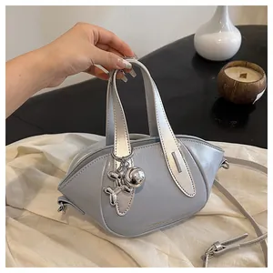 Detailed view of a grey glossy women's bucket bag featuring a silver balloon dog charm.